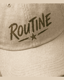 Cream El Spot dad cap with an olive ROUTINE script and star.