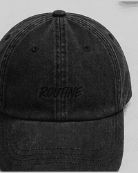 Washed black dad hat with a tonal ROUTINE script on the front.