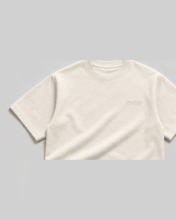Cream heavyweight tee with a small tonal ROUTINE script on the chest.