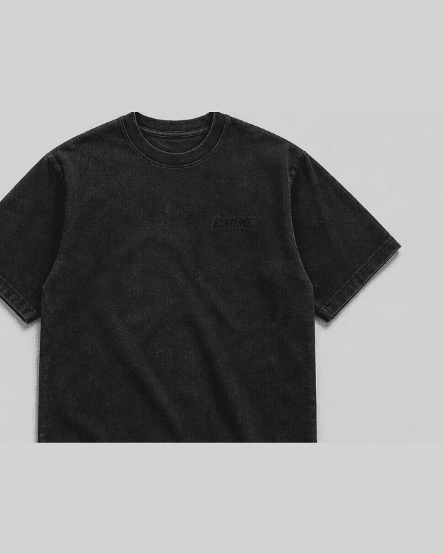 Washed black heavyweight tee with a small tonal ROUTINE script on the chest.