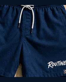 Navy La Isla swim trunks with a white drawcord and a ROUTINE script on the leg.