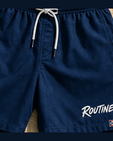 Navy La Isla swim trunks with a white drawcord and a ROUTINE script on the leg.