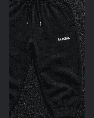 Black Night Drive sweatpants with a small white ROUTINE script on the thigh.